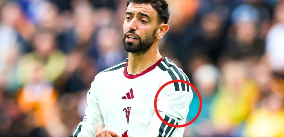 Futbolchi maydonda harakatda, o'ng qo'lini ko'targan