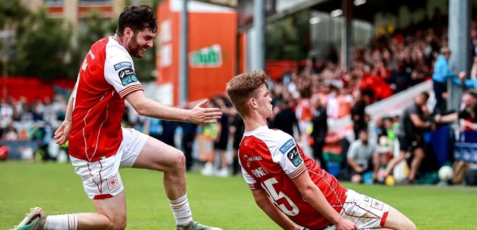 Two players celebrating a goal on the pitch