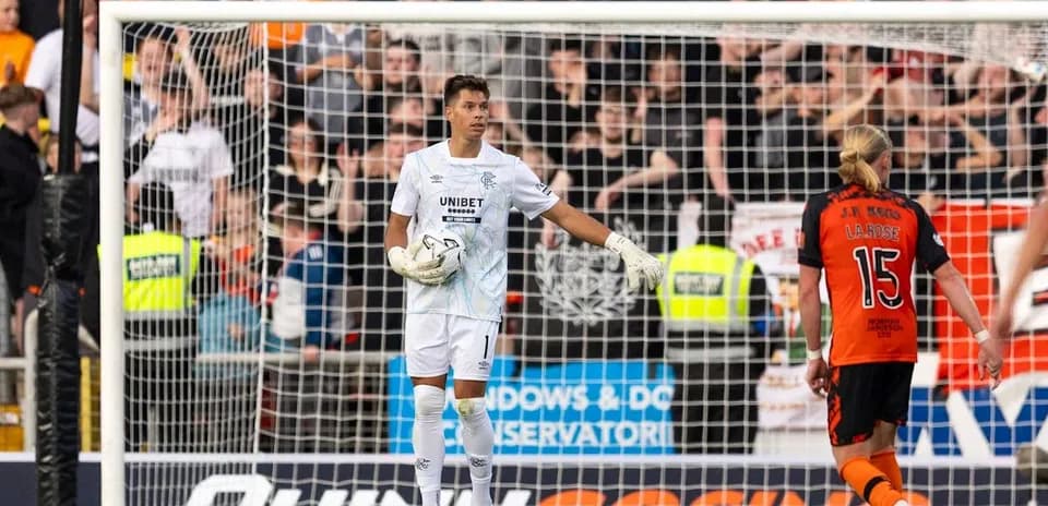 Goalkeeper gesturing during match with players behind