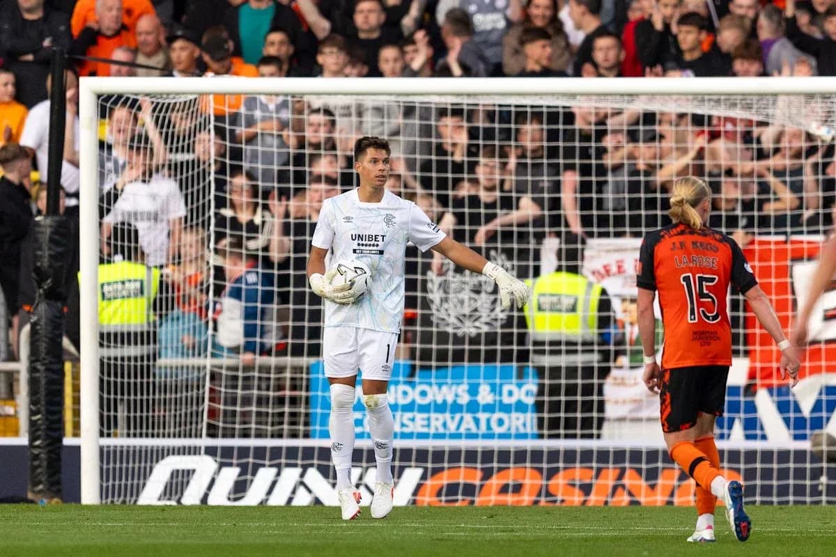 Goalkeeper gesturing during match with players behind