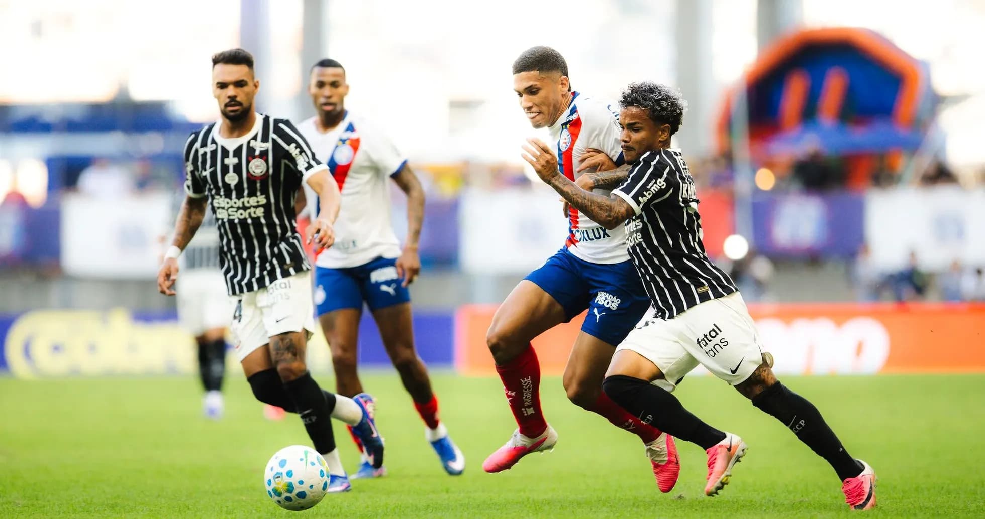 Futbol o'yinida to'p uchun kurashayotgan o'yinchilar