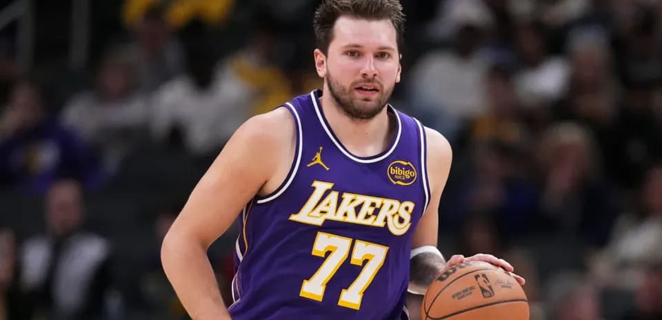 O'yinchi Lakers formasida to'pni olib ketmoqda