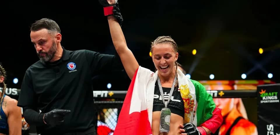Fighter celebrating victory with referee in octagon