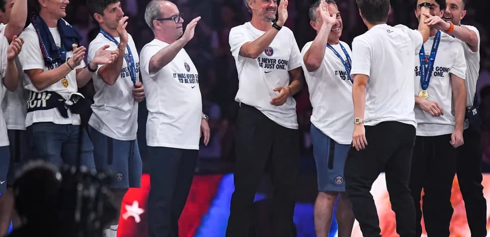Coaches and staff celebrating with medals on stage