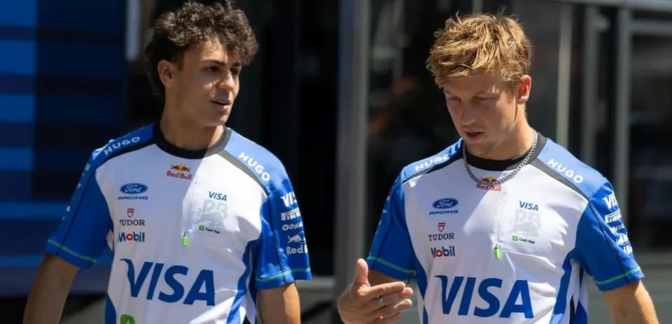 Two drivers in team uniforms walking and talking