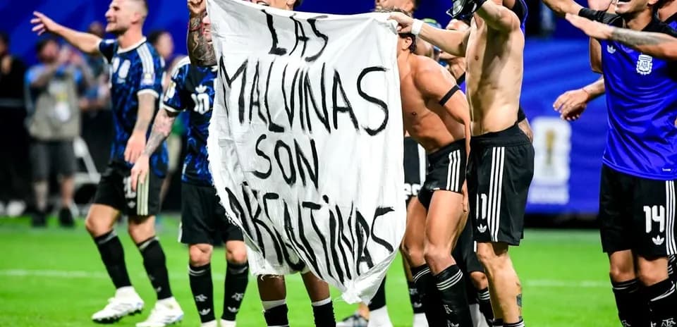 Futbolchilar bayroq bilan maydonda nishonlayapti