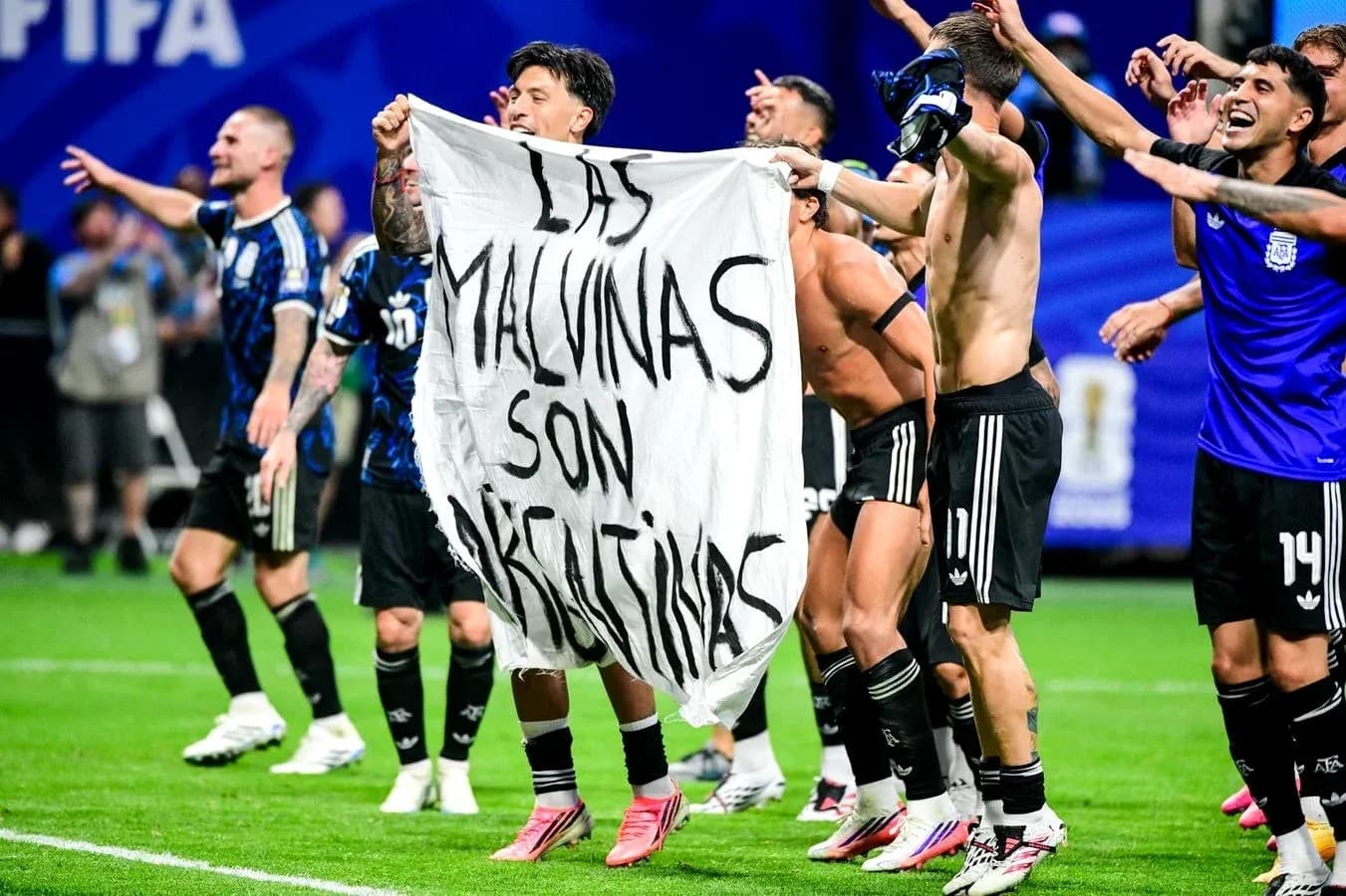Futbolchilar bayroq bilan maydonda nishonlayapti