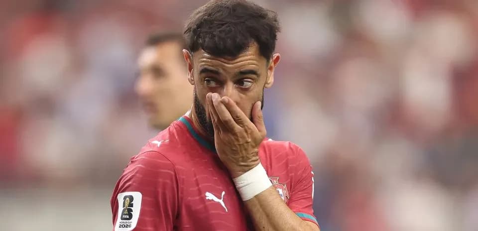 Futbolchi o'yin davomida qo'lini yuzi bilan to'smoqda