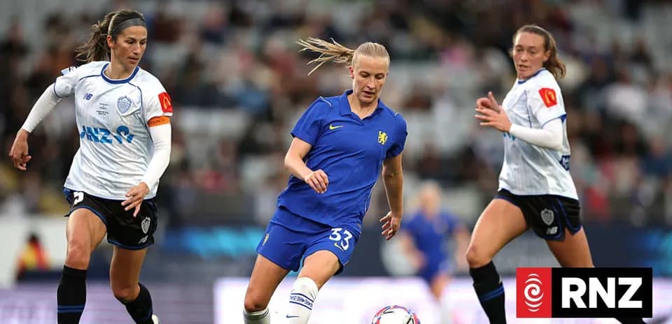 Three female football players competing for the ball