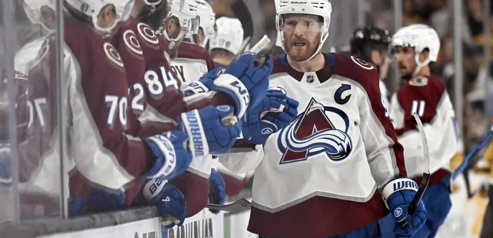 Hockey player celebrating with teammates on bench
