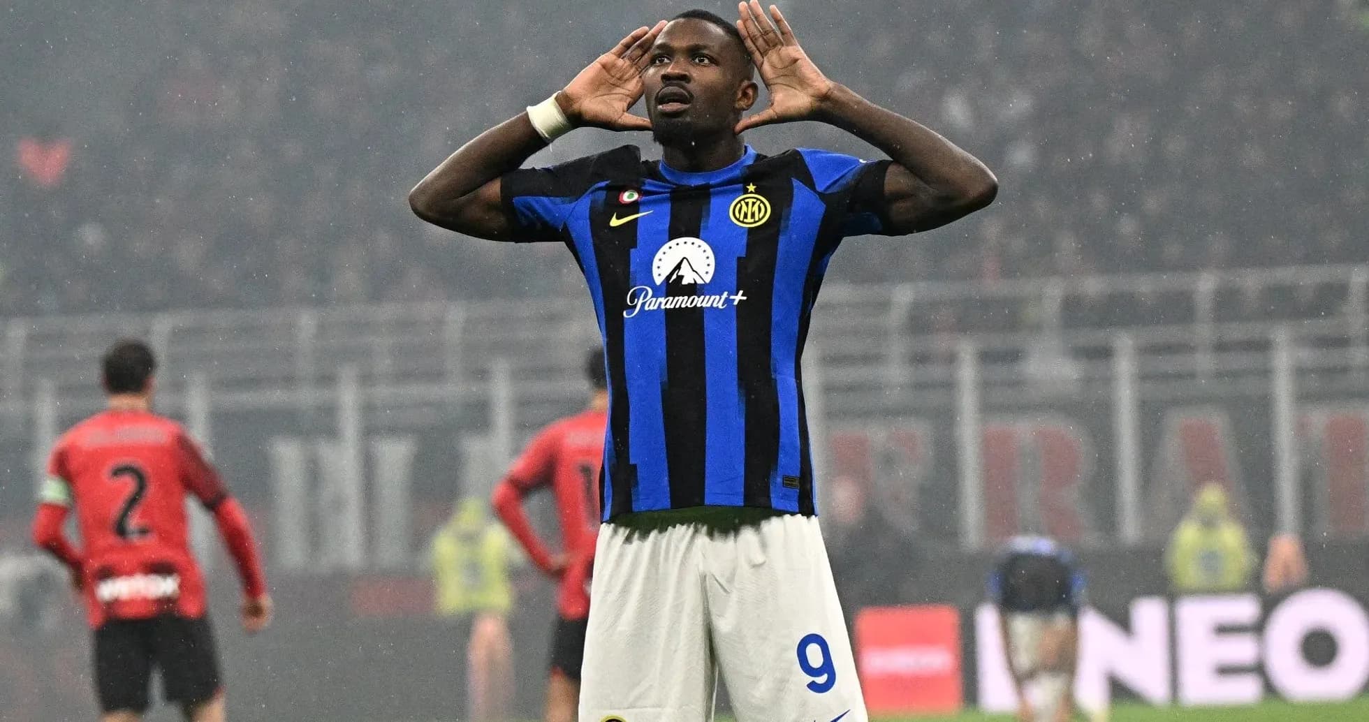 Futbolchi gol urib, qo'llarini eshitishga qo'ygan Futbolchi gol urib, qo'llarini eshitishga qo'ygan