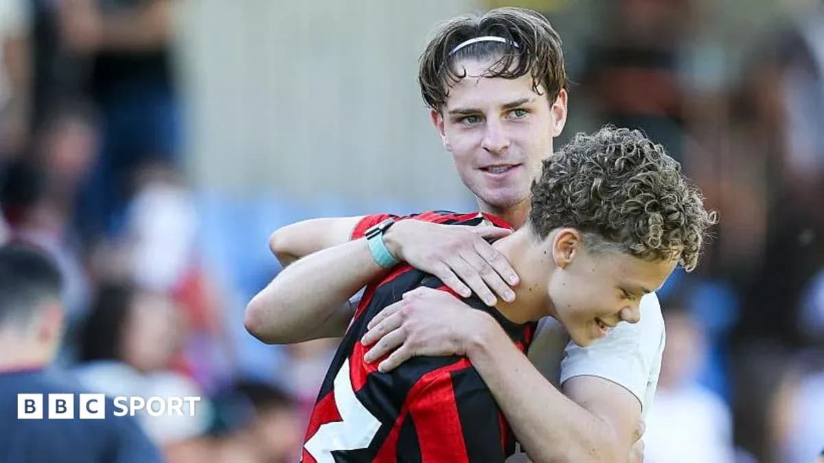 Two players embracing on the field after match Two players embracing on the field after match