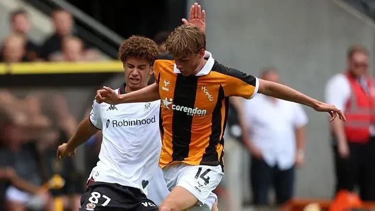 Player tackling opponent during a football match Player tackling opponent during a football match