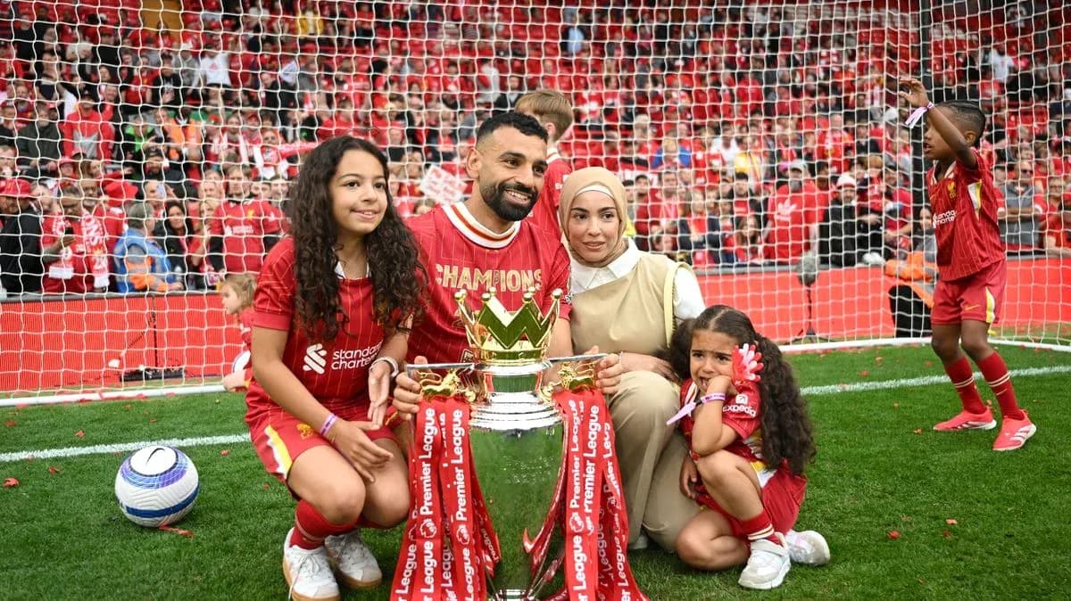 Futbolchi va oilasi Premier League kubogini ushlab turibdi Futbolchi va oilasi Premier League kubogini ushlab turibdi