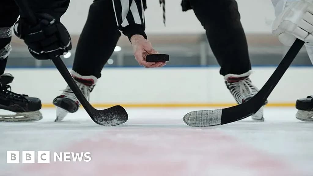 Referee dropping puck for face-off in ice hockey Referee dropping puck for face-off in ice hockey
