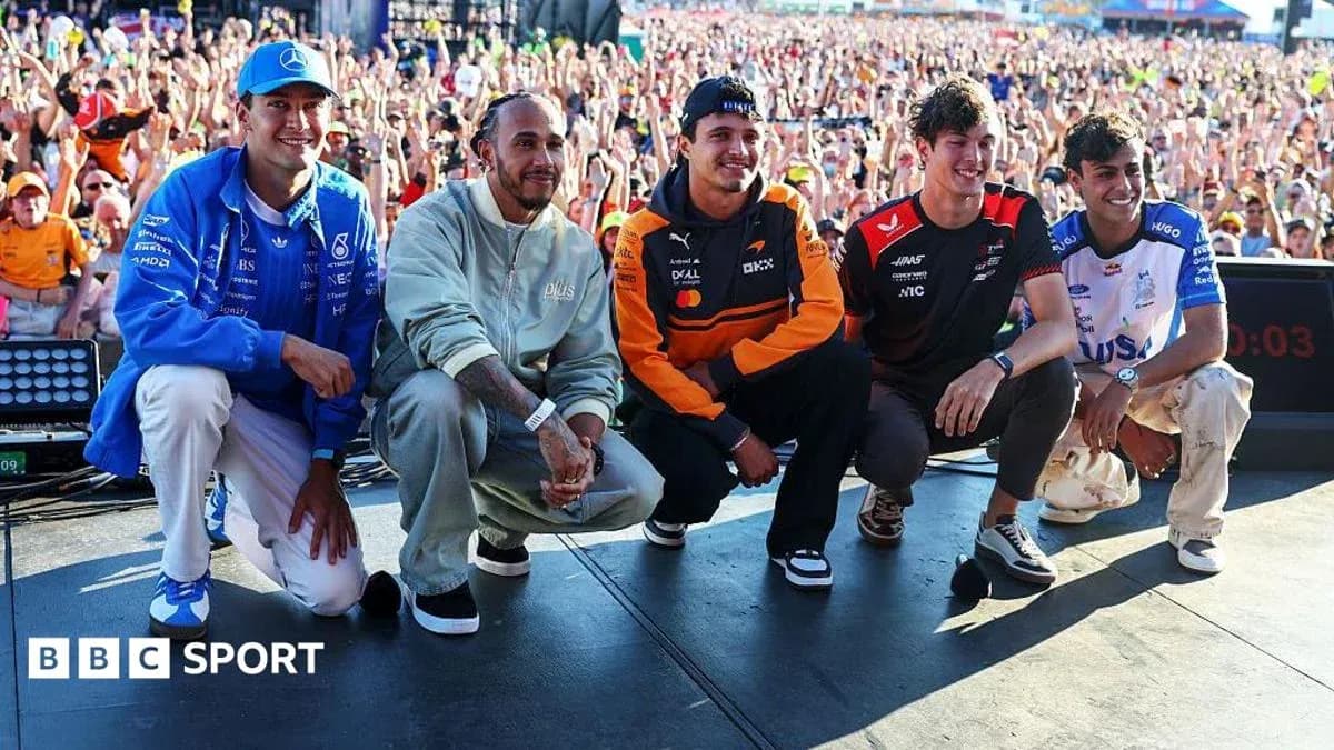 Formula 1 drivers posing on stage with crowd behind Formula 1 drivers posing on stage with crowd behind