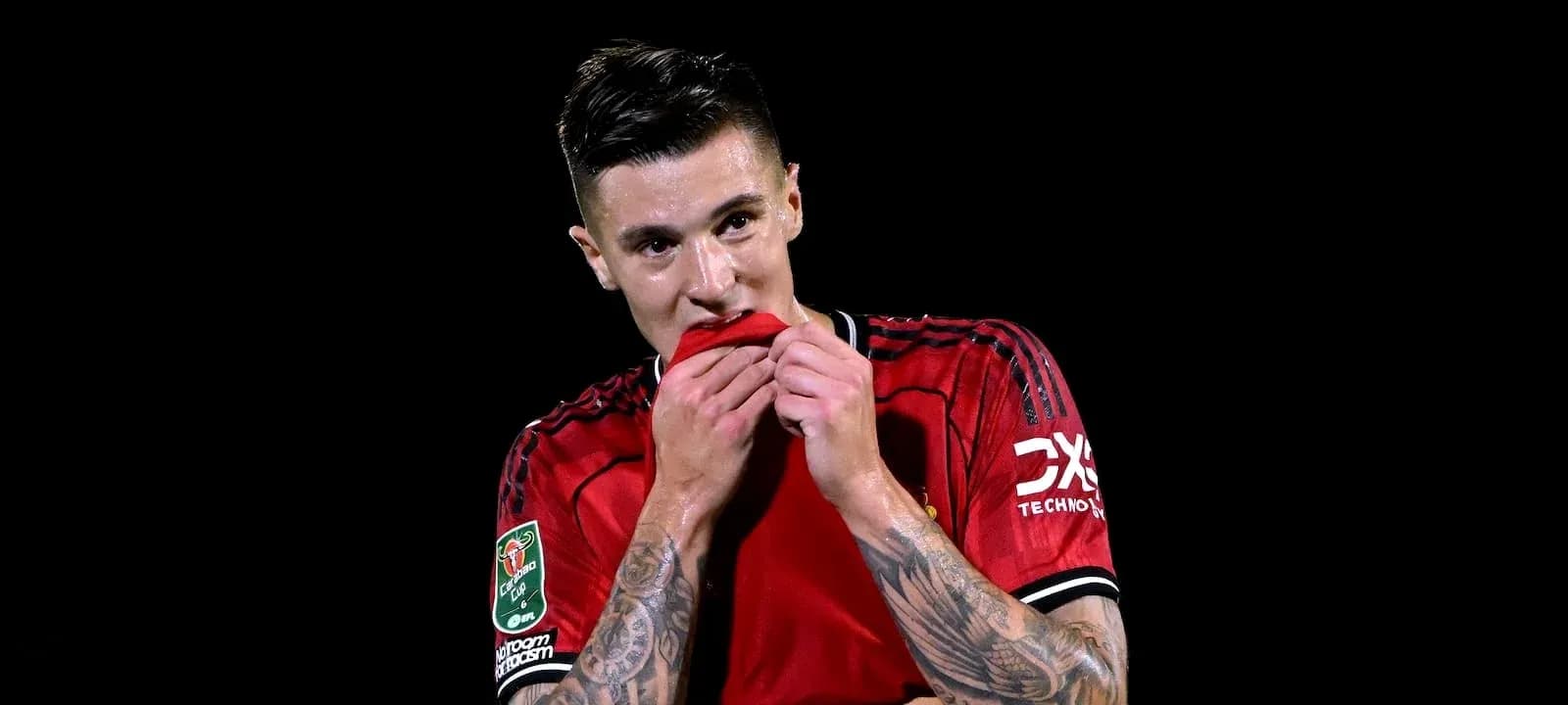 Futbolchi qizil formada ko'ylakni tishlayapti Futbolchi qizil formada ko'ylakni tishlayapti