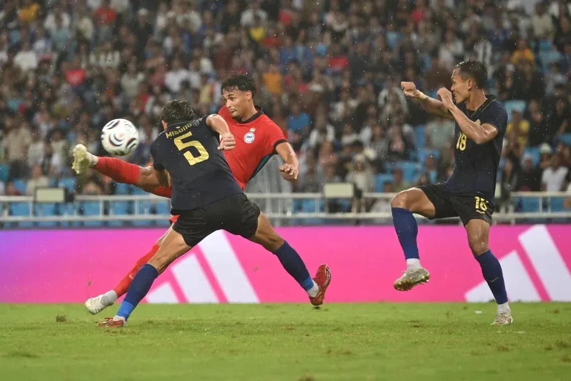 Three players competing for the ball in rain Three players competing for the ball in rain