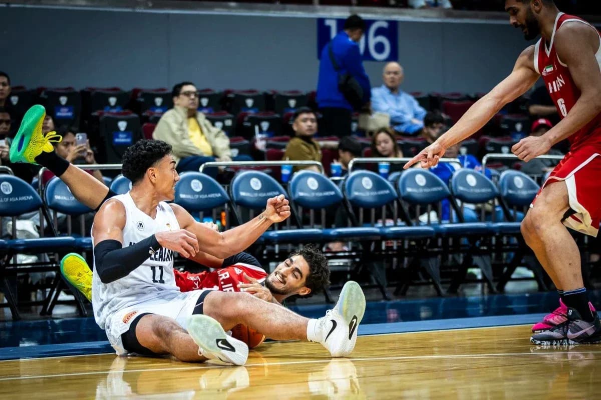 Two basketball players on the court, one falling Two basketball players on the court, one falling