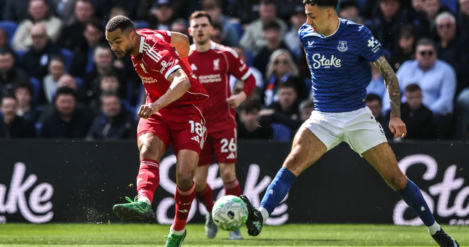 Liverpool and Everton players competing for the ball Liverpool and Everton players competing for the ball