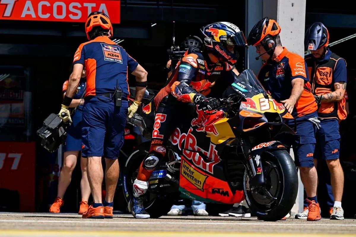 Rider preparing to leave pit box on motorcycle Rider preparing to leave pit box on motorcycle