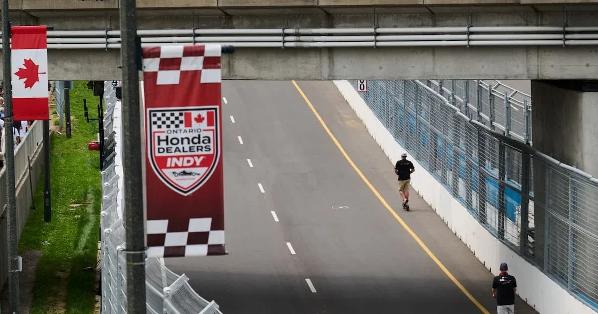 Two people walking on the race track at Indy Two people walking on the race track at Indy