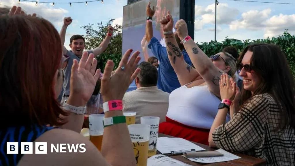 People celebrating with raised hands at outdoor venue People celebrating with raised hands at outdoor venue