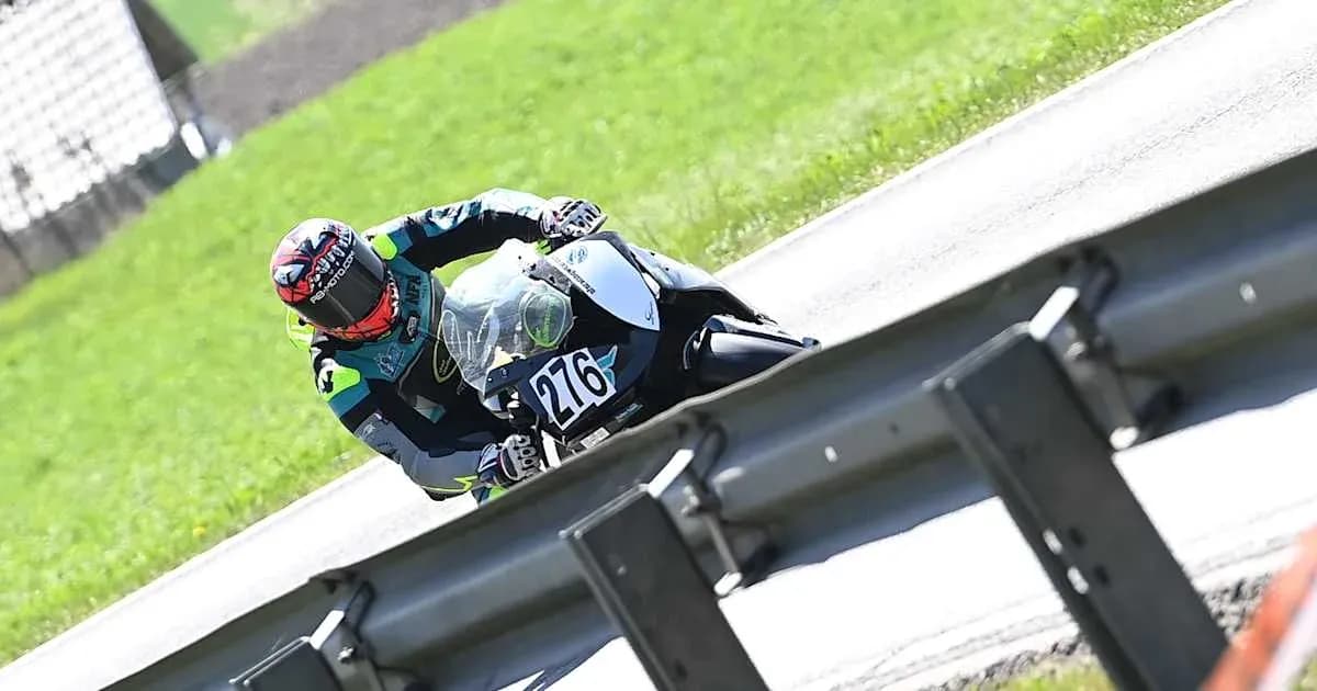 Rider leaning into a turn on motorcycle at track Rider leaning into a turn on motorcycle at track