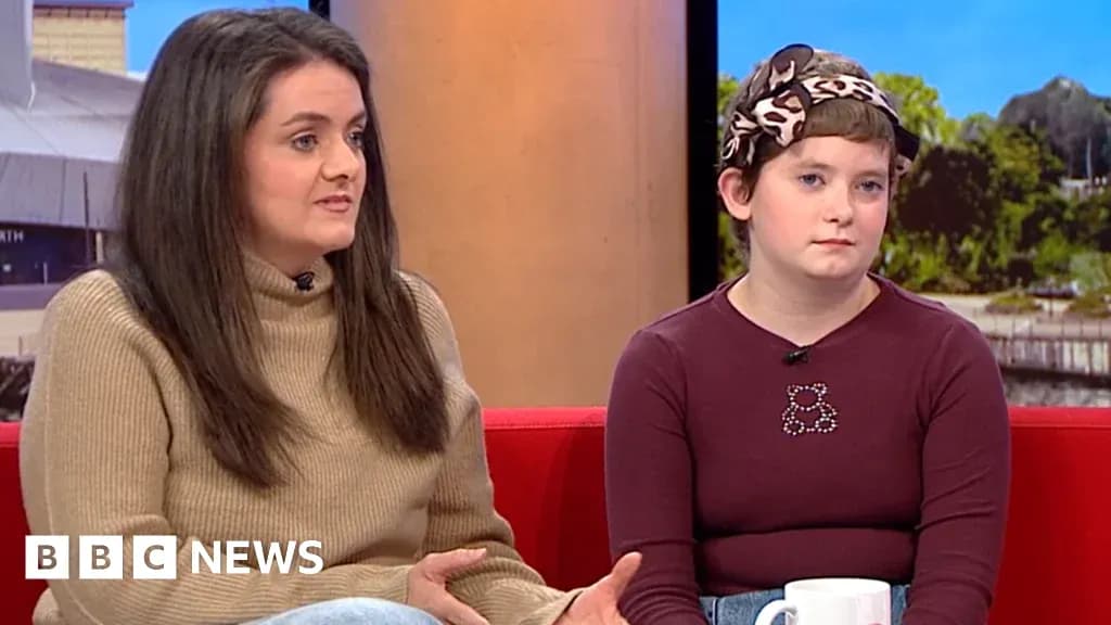 Two women sitting on a red sofa during interview Two women sitting on a red sofa during interview