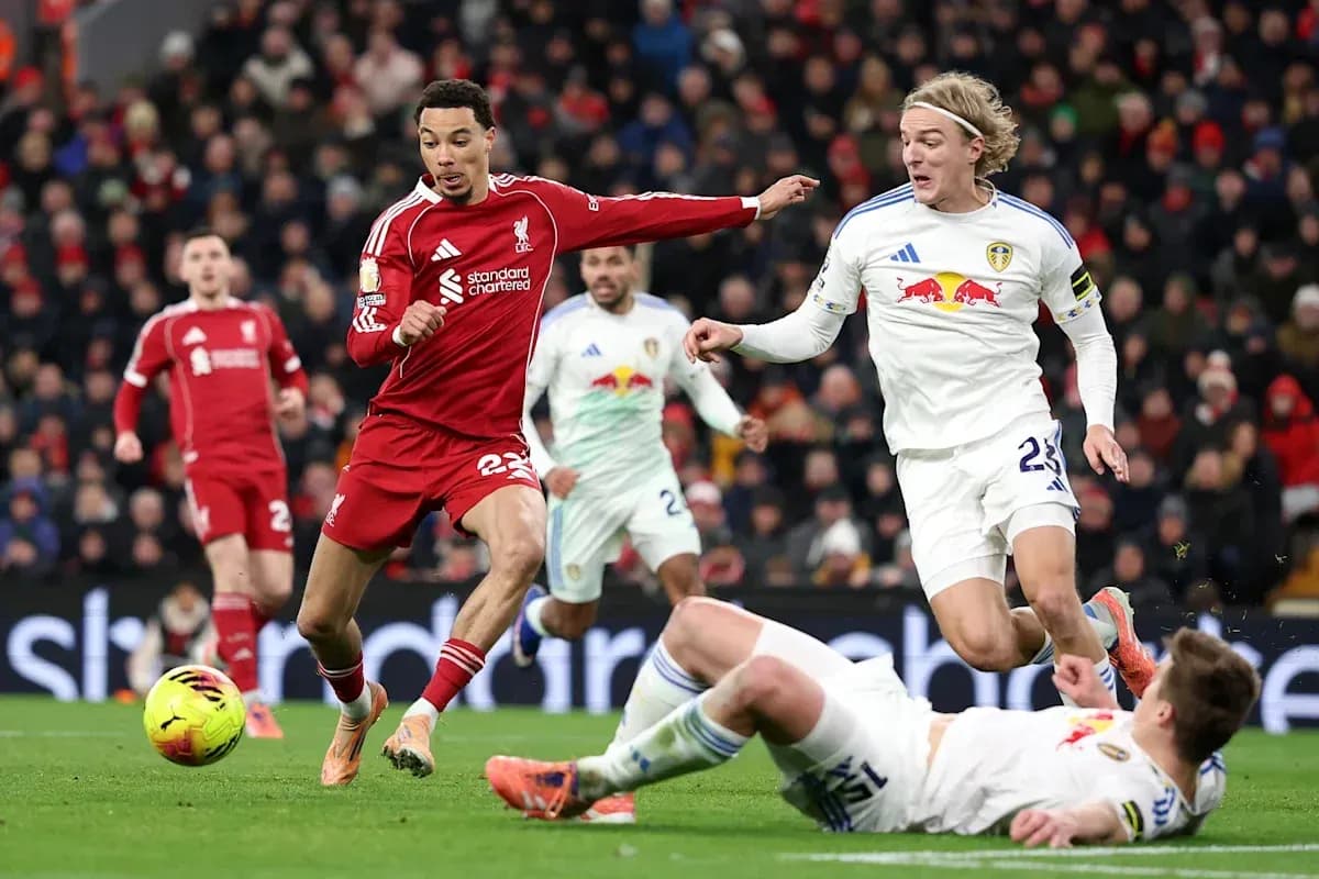 Liverpool player dribbling past Leeds opponents on pitch Liverpool player dribbling past Leeds opponents on pitch