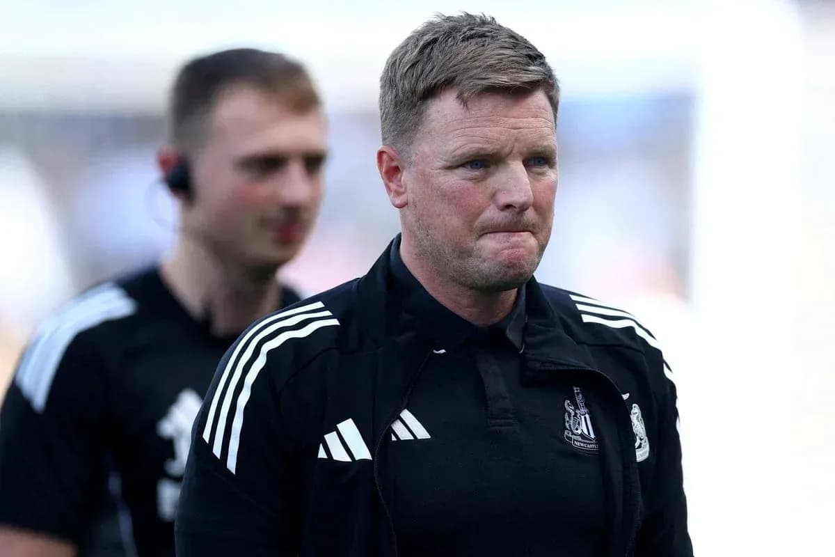Football manager walking on pitch with staff member Football manager walking on pitch with staff member