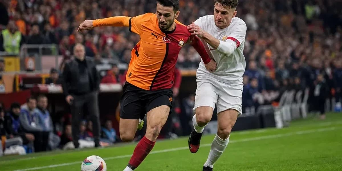 Galatasaray player being challenged by opponent during match Galatasaray player being challenged by opponent during match
