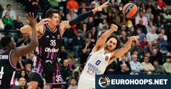 Basketball player shooting while defended by opponent Basketball player shooting while defended by opponent