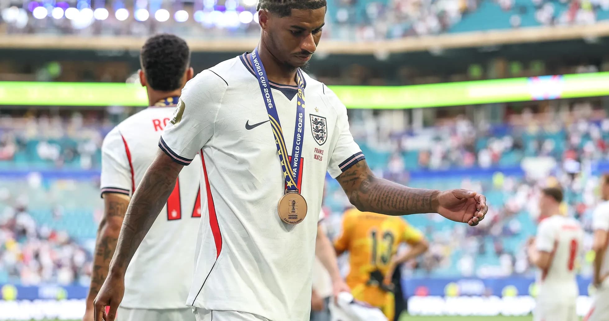 Player walking off field with bronze medal Player walking off field with bronze medal