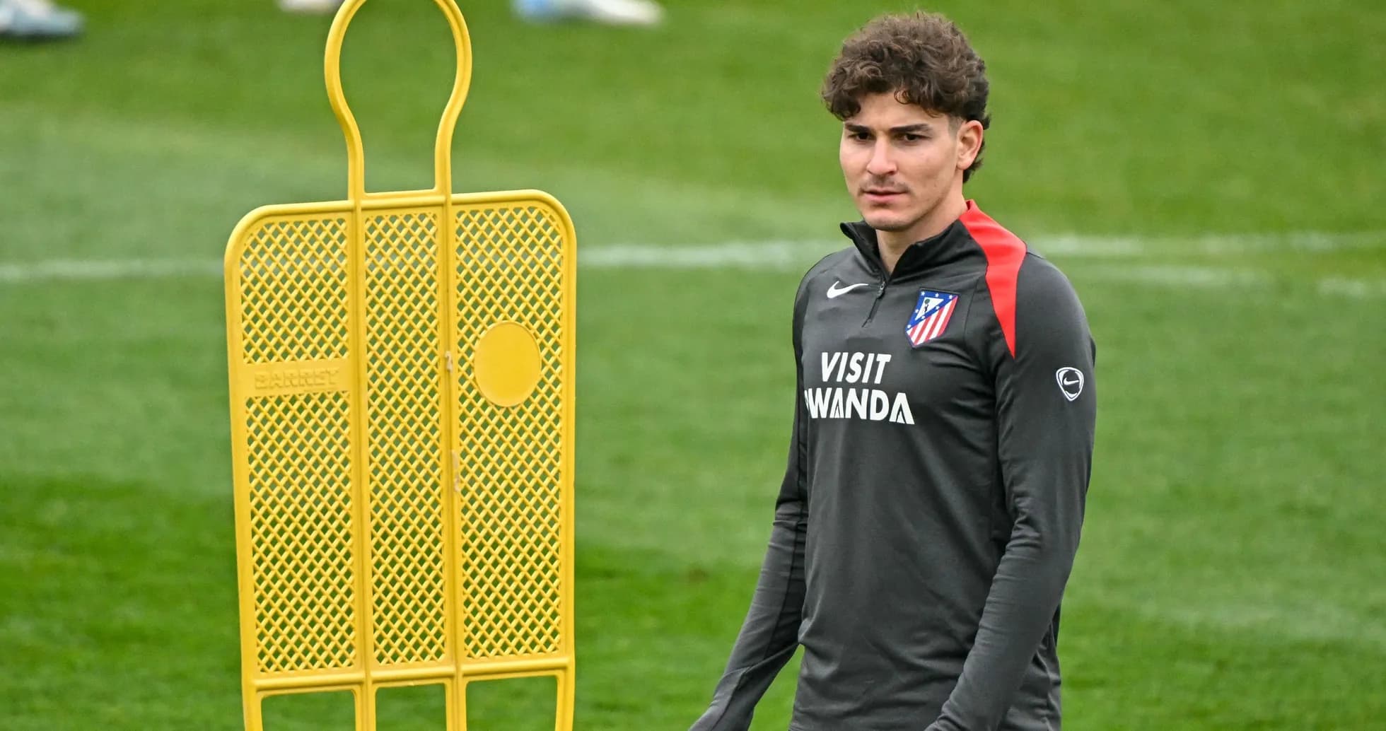 Futbolchi treningda saralangan to'siq yonida Futbolchi treningda saralangan to'siq yonida