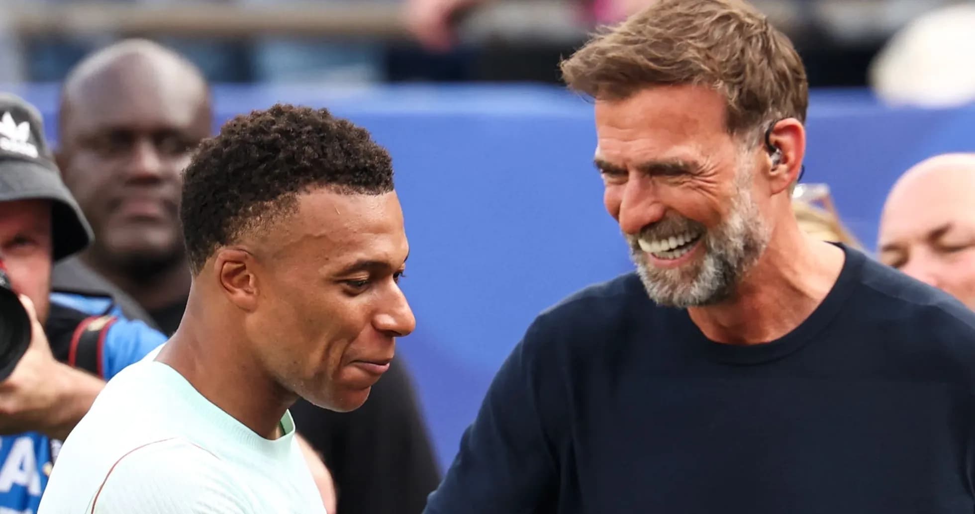 Kylian Mbappé and coach smiling during interaction Kylian Mbappé and coach smiling during interaction