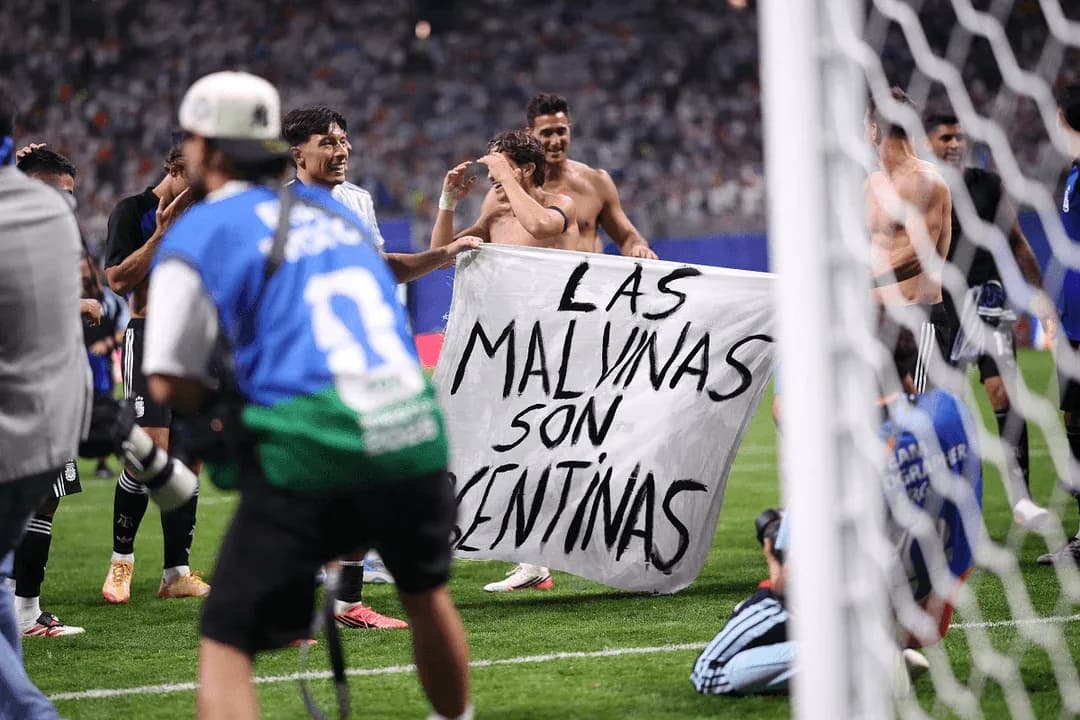 Players celebrating with a banner after match Players celebrating with a banner after match
