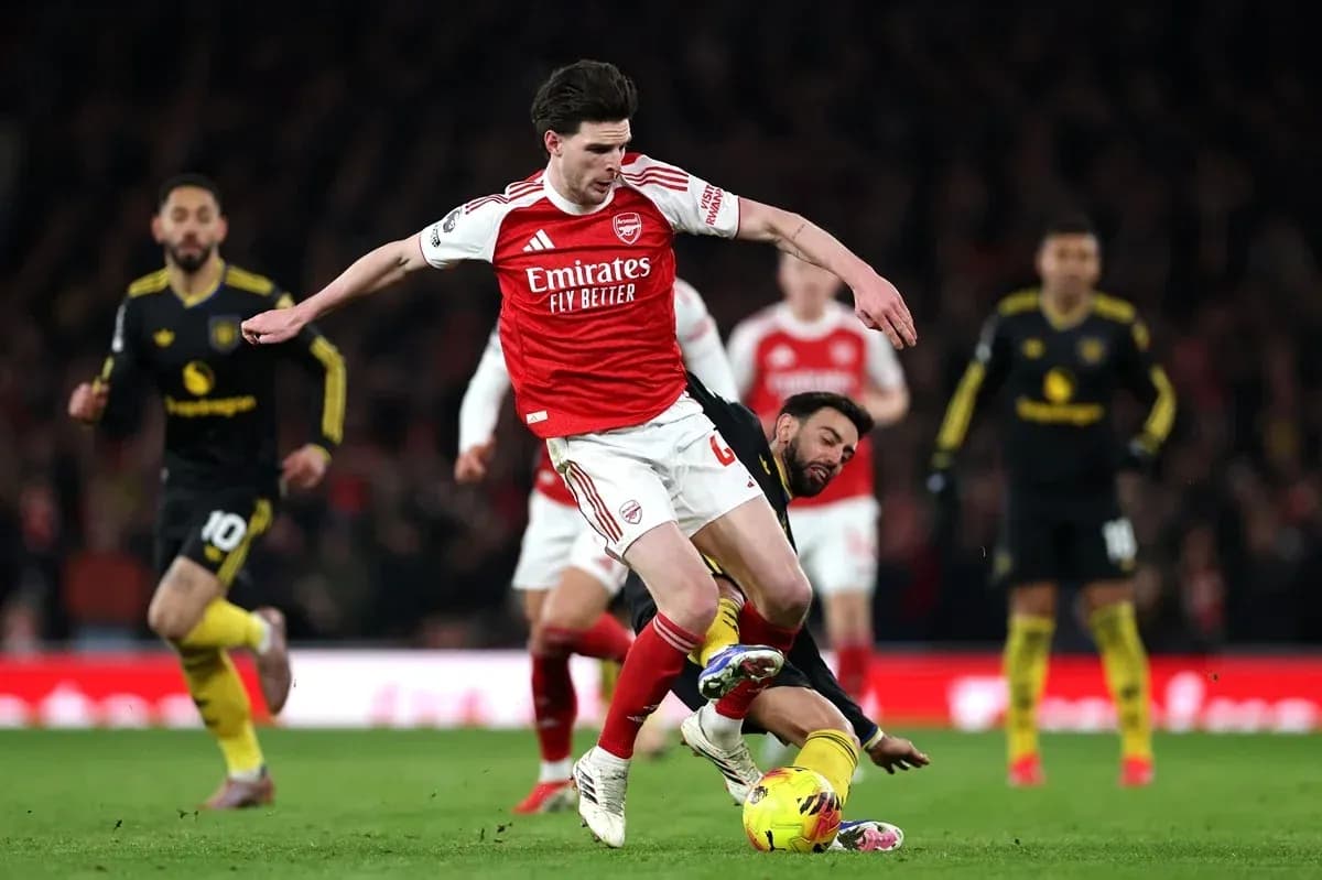 Arsenal player tackling opponent during match action Arsenal player tackling opponent during match action
