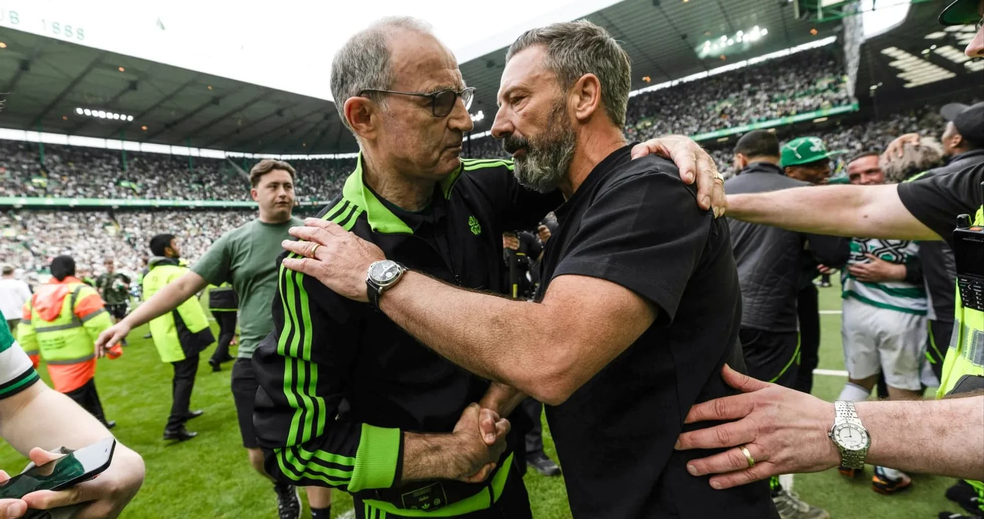 Trainers embracing on the pitch after match Trainers embracing on the pitch after match