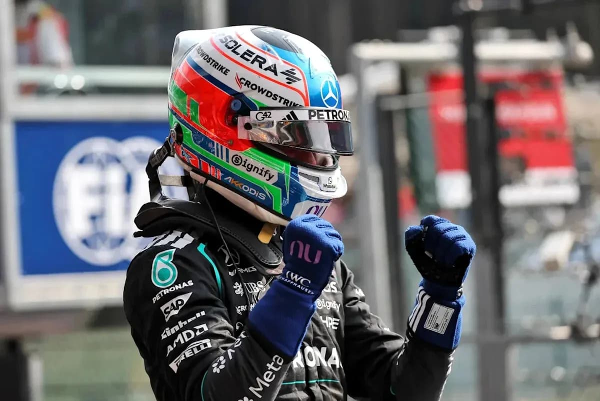 Formula 1 driver celebrating in racing suit and helmet Formula 1 driver celebrating in racing suit and helmet