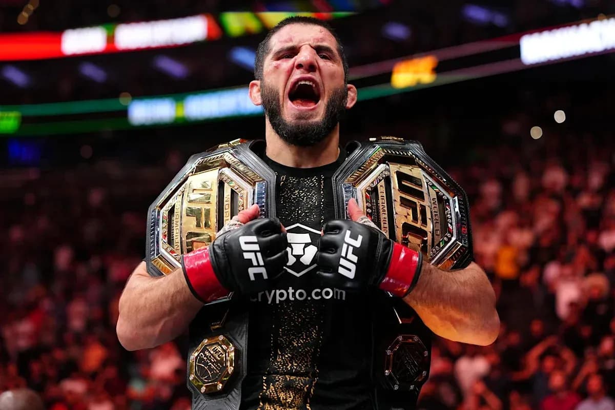 Fighter celebrating with two UFC championship belts Fighter celebrating with two UFC championship belts