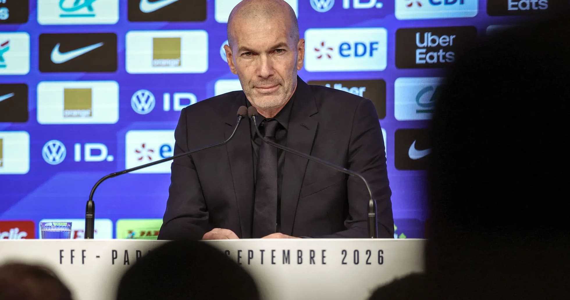 Zinedine Zidane speaking at press conference podium Zinedine Zidane speaking at press conference podium