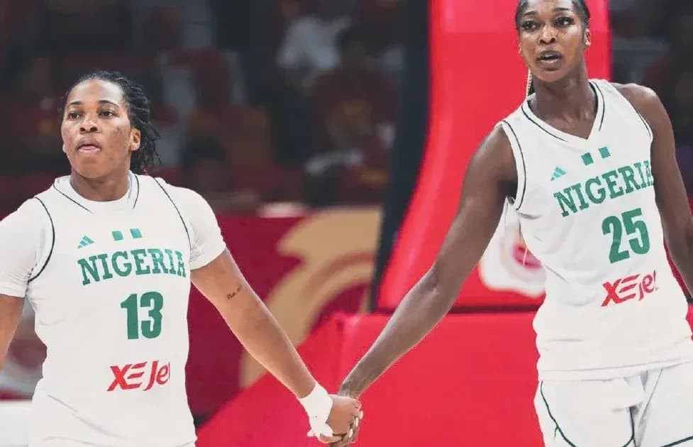 Two Nigerian basketball players holding hands on court Two Nigerian basketball players holding hands on court