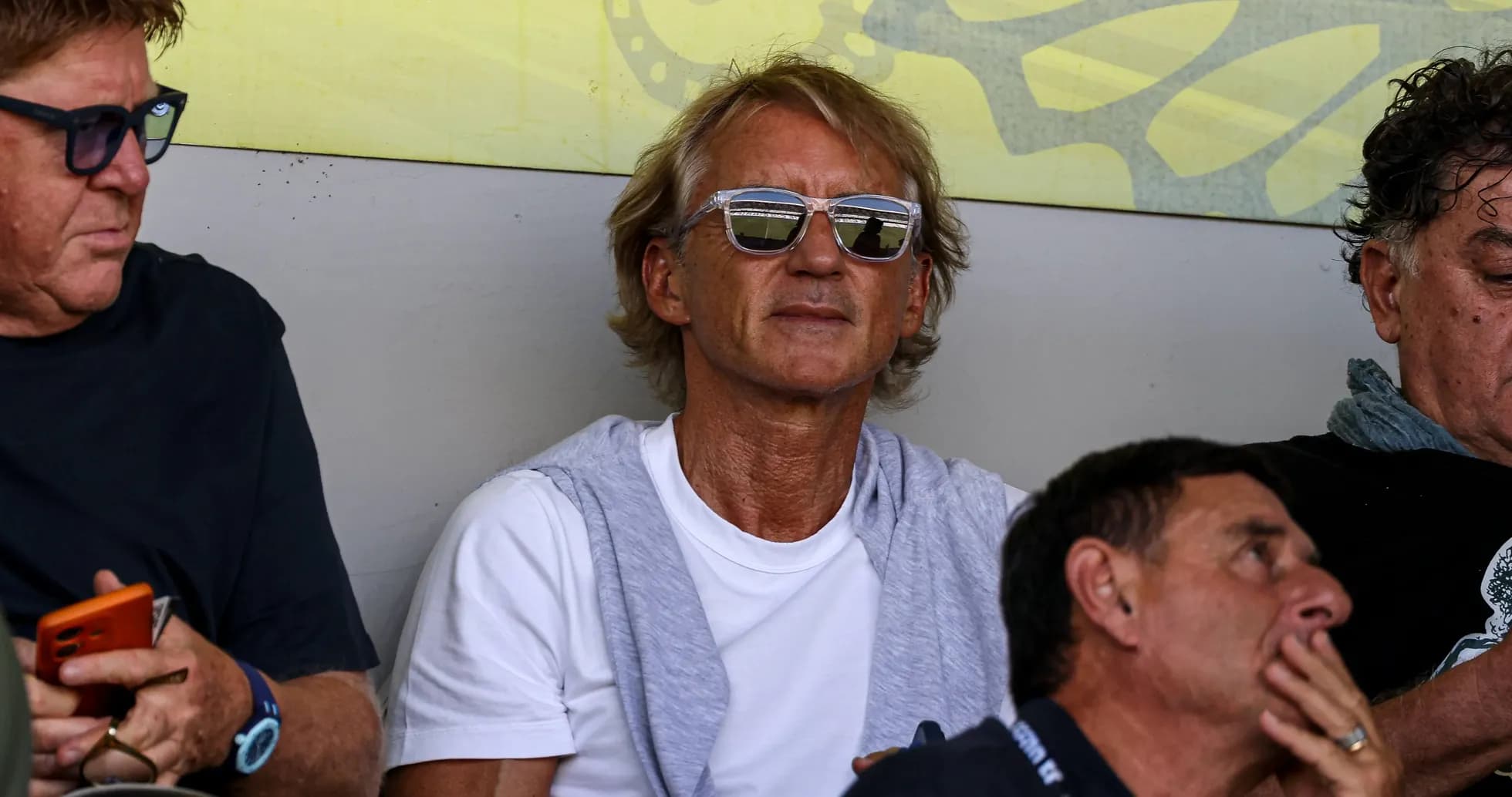 Man wearing sunglasses sitting in crowd Man wearing sunglasses sitting in crowd