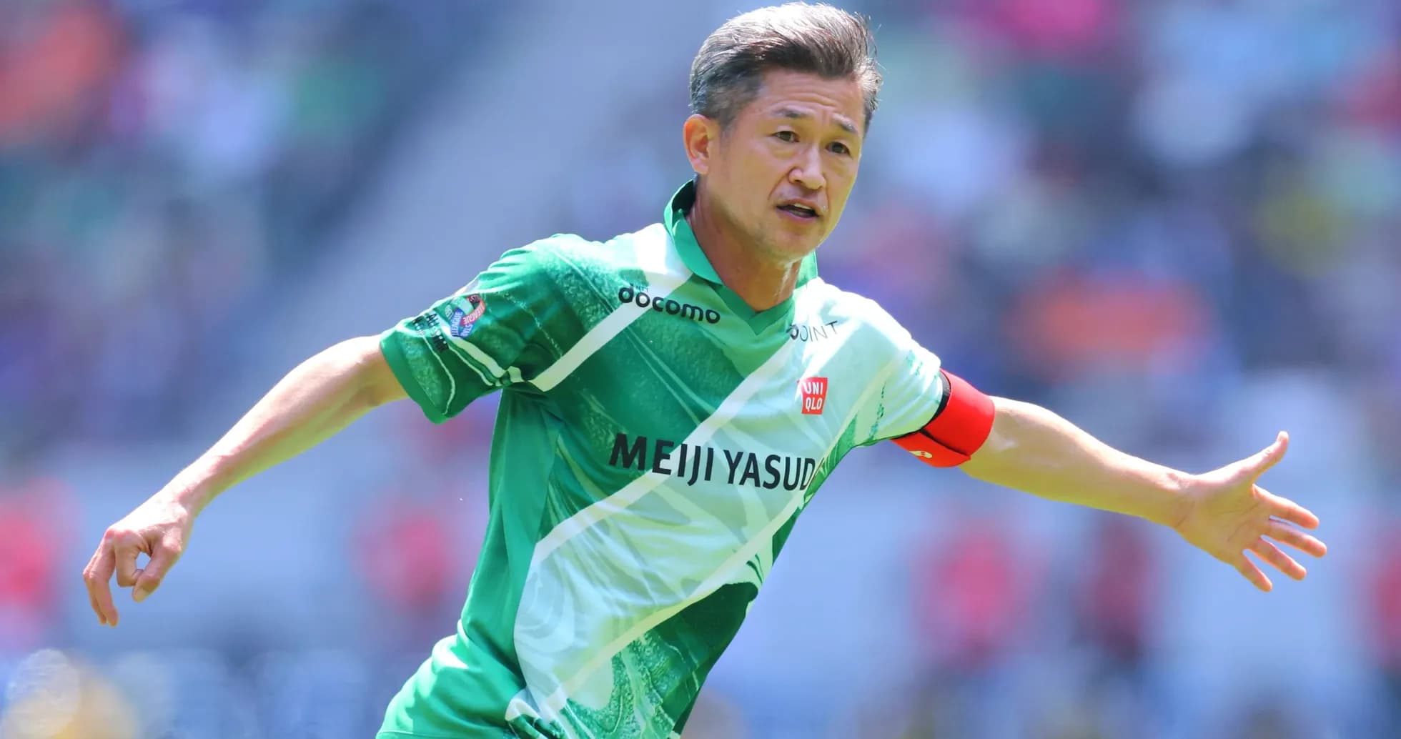 Futbolchi maydonda harakatda, yashil forma kiygan Futbolchi maydonda harakatda, yashil forma kiygan