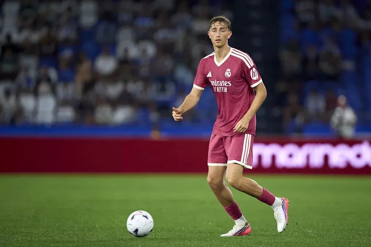 Futbolchi Real Madrid formasida to'pni ushlayotgan Futbolchi Real Madrid formasida to'pni ushlayotgan