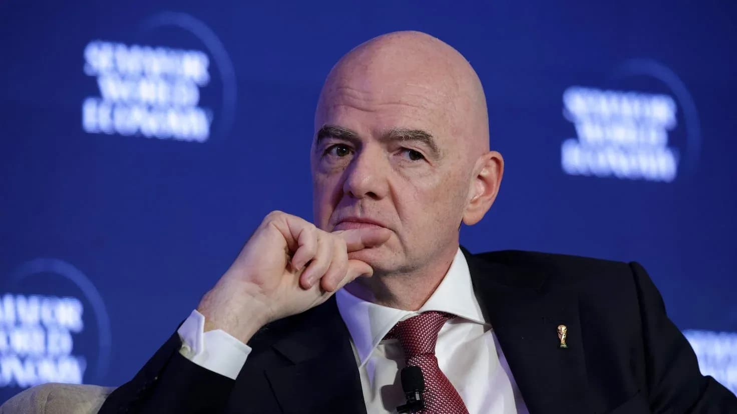 Man speaking at a conference with FIFA logo pin Man speaking at a conference with FIFA logo pin