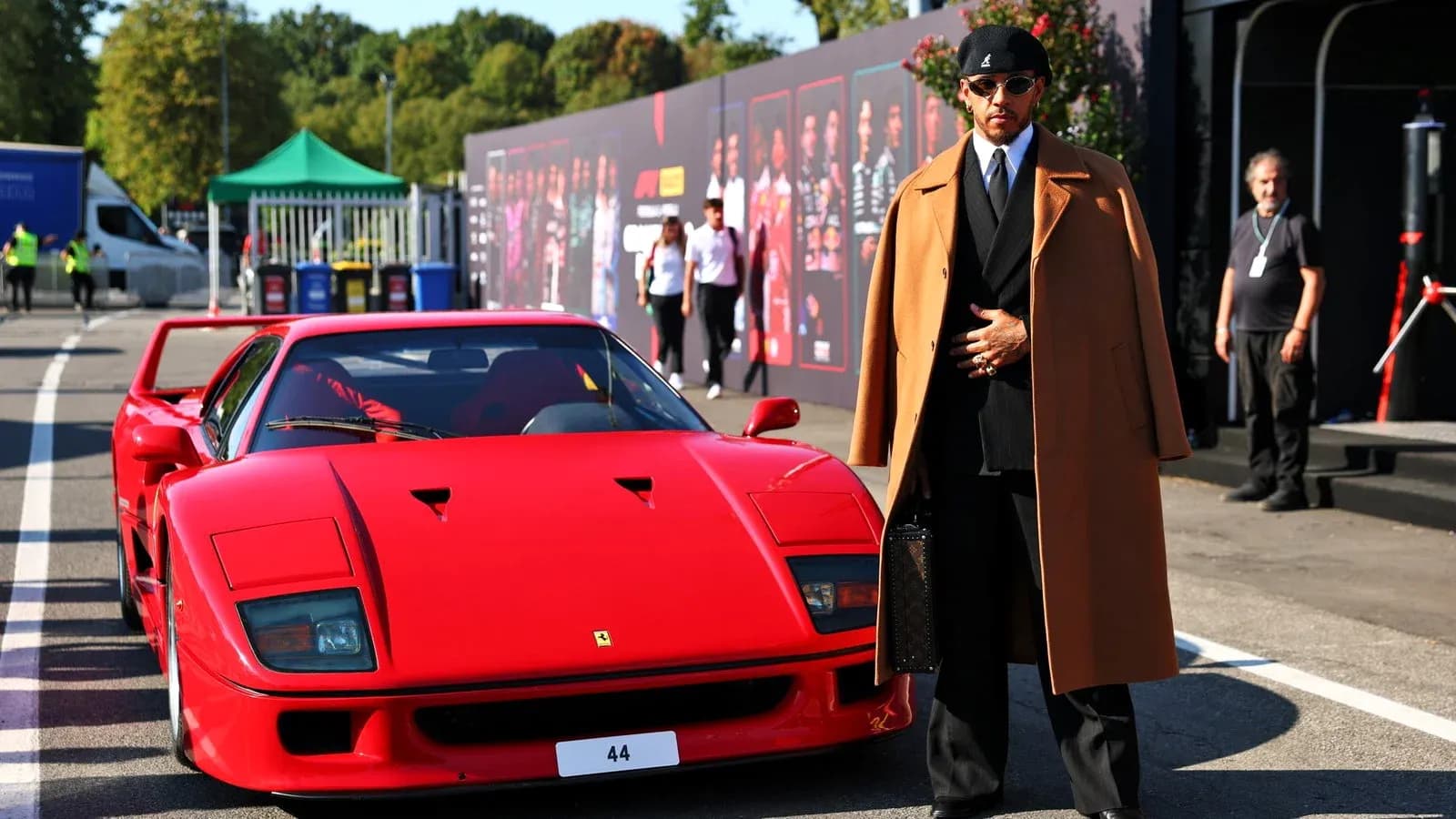 Shirted man standing next to red Ferrari F40 Shirted man standing next to red Ferrari F40