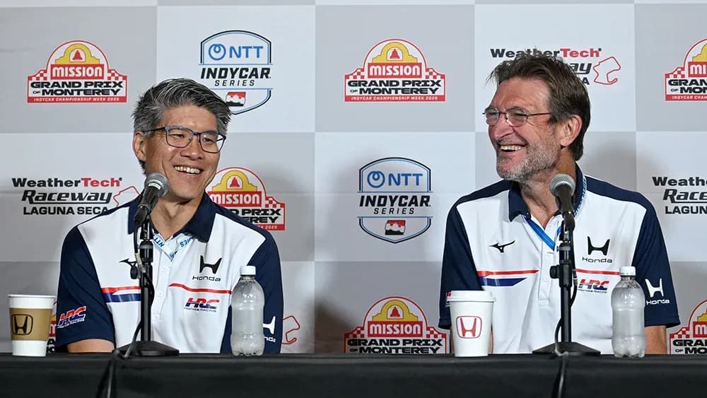 Two men at press conference with Honda branding Two men at press conference with Honda branding