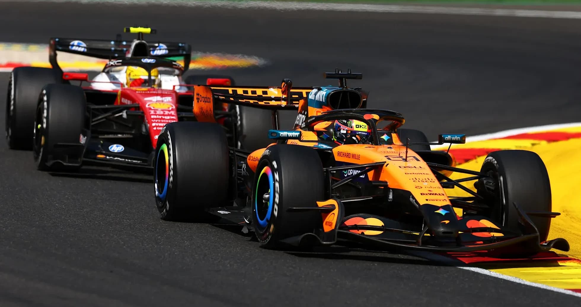 McLaren and Ferrari cars racing on track McLaren and Ferrari cars racing on track